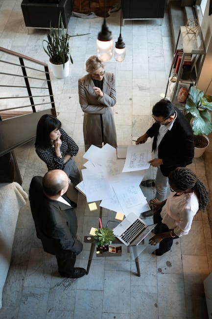 Team diskutiert an einem Tisch mit vielen Zetteln über Ideen zur Cloud-Kommunikation.