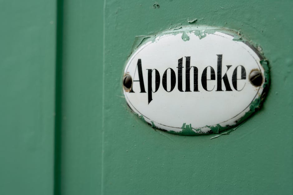 Schild mit der Aufschrift „Apotheke“ an grüner Wand im Kontext der Telepharmazie-Apotheke